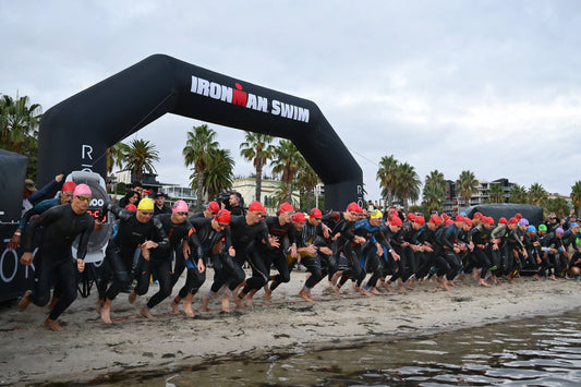 Ironman athletes running into the water at the start of the ironman 70.3 swim.